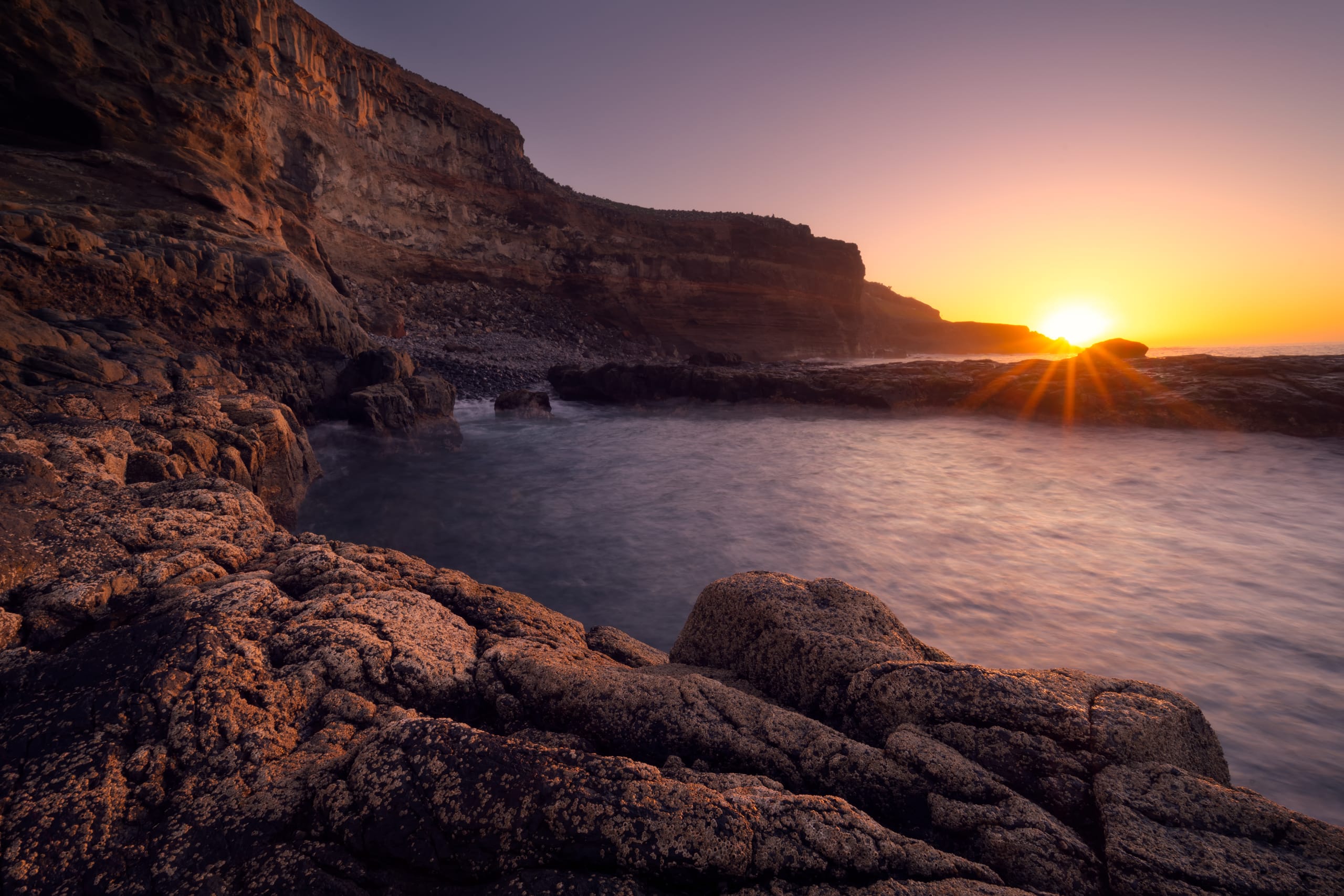 Rocky sea cliff at golden sunset, Gran Canaria coastline