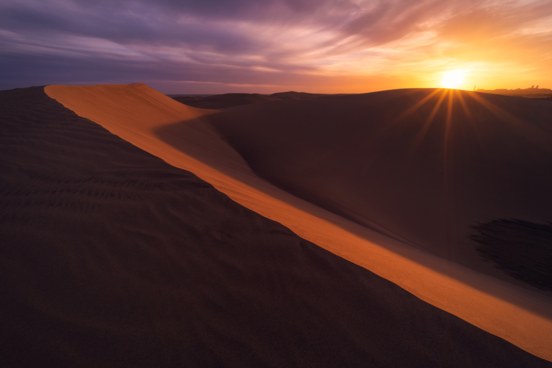 Sand dune ridge at sunrise with sunburst, Maspalomas Gran Canaria