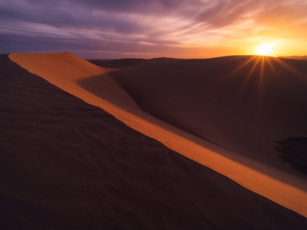 Sand dune ridge at sunrise with sunburst, Maspalomas Gran Canaria
